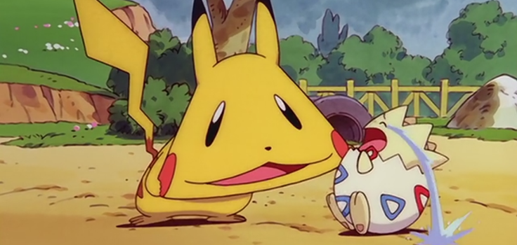 Pikachu attempting to soothe Togepi by pulling a funny face